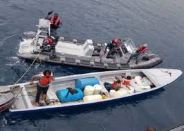 In a boat, how should firearms be transported?